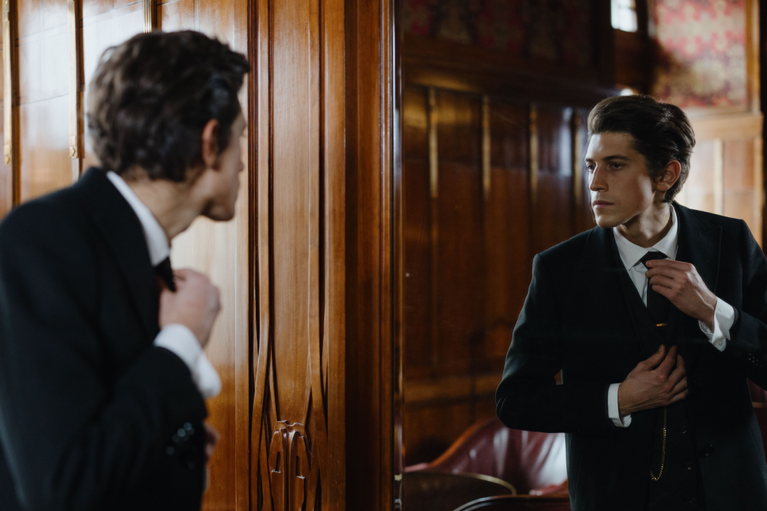 A man getting ready in front of a mirror before going out