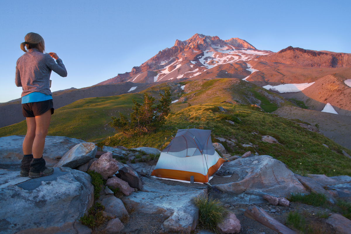 A camper brushing teeth outdoors at a campsite